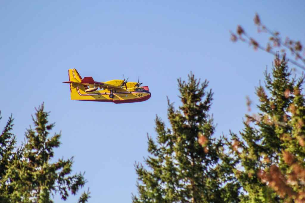 a yellow aircraft flying in the sky